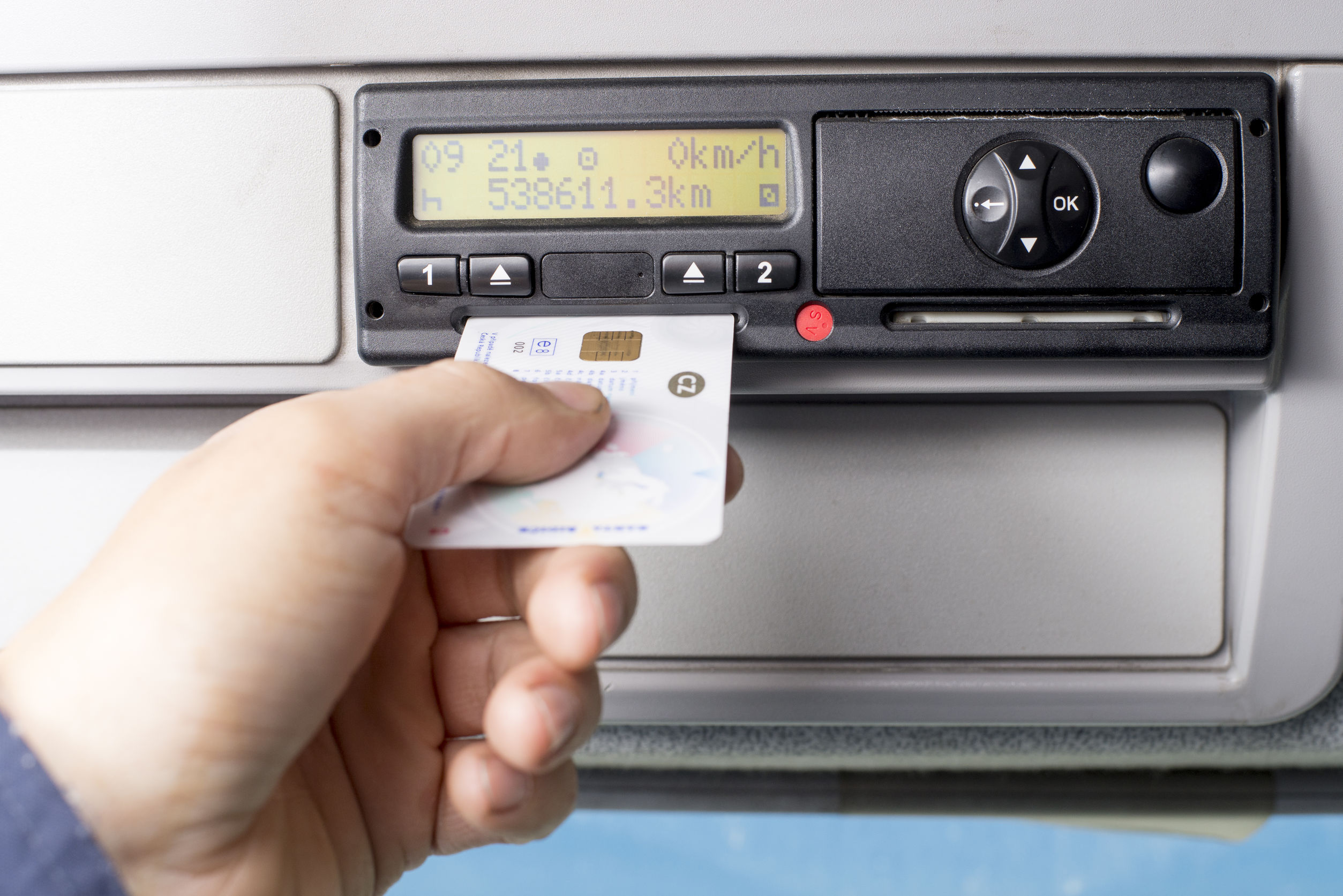 Digital tachograph and drivers hand inserting the digital card